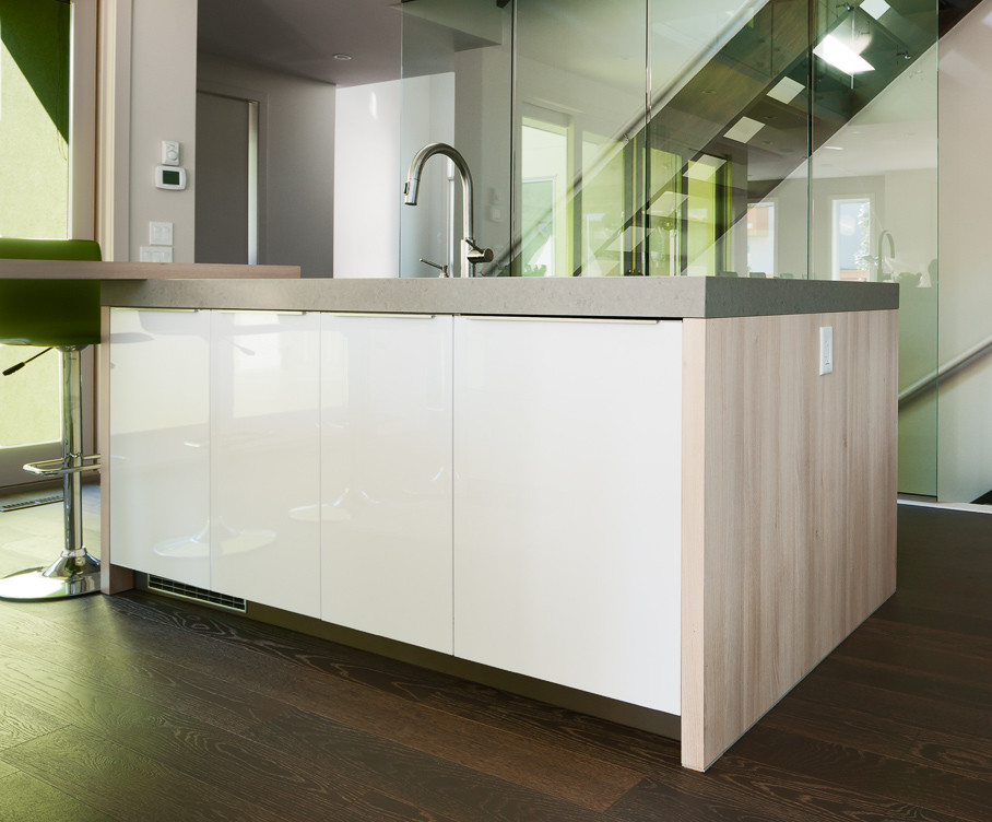 Esempio di una cucina minimalista con lavello sottopiano, ante lisce, ante in legno chiaro, top in quarzo composito, paraspruzzi con piastrelle di vetro e elettrodomestici da incasso