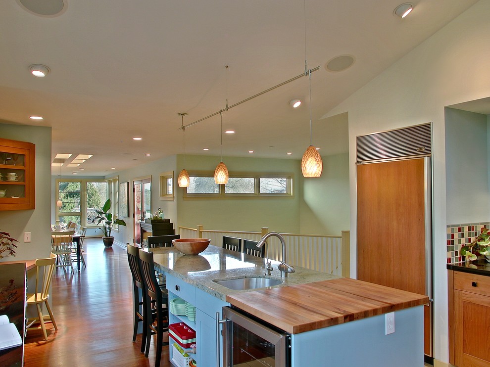 This is an example of a contemporary kitchen/diner in Seattle with medium wood cabinets and integrated appliances.