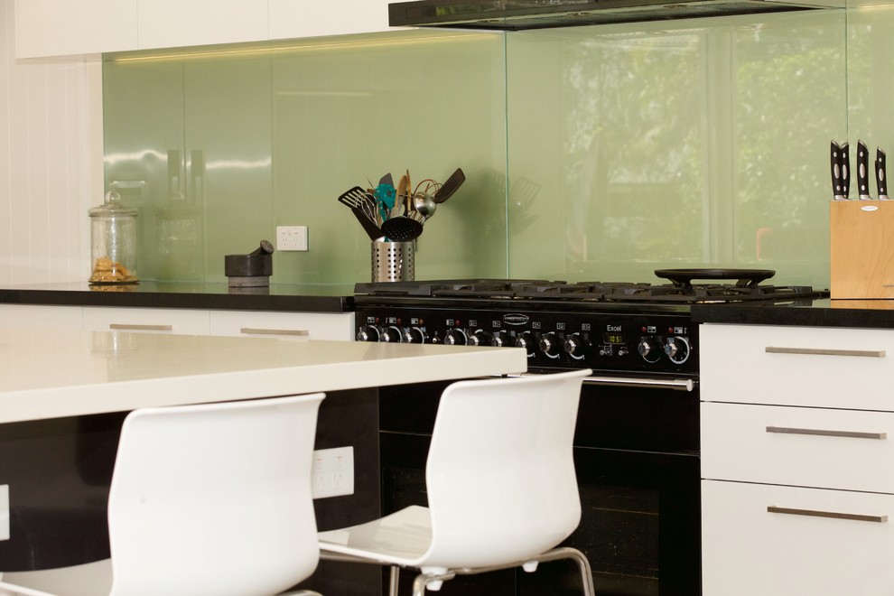 Esempio di una grande cucina moderna con lavello sottopiano, ante lisce, ante bianche, top in quarzo composito, paraspruzzi con lastra di vetro, elettrodomestici neri e pavimento con piastrelle in ceramica