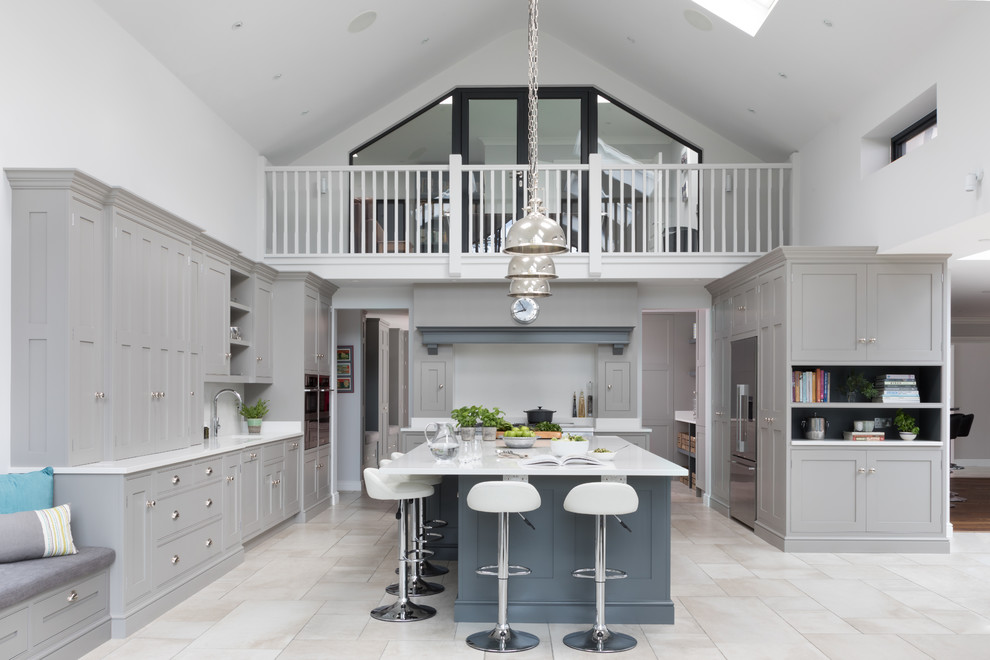 Klassische Küche in U-Form mit Schrankfronten im Shaker-Stil, grauen Schränken, Kücheninsel, grauem Boden und weißer Arbeitsplatte in Surrey