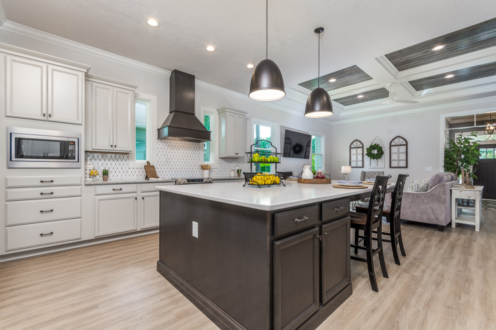 Immagine di una cucina con paraspruzzi bianco, paraspruzzi con piastrelle a mosaico, elettrodomestici in acciaio inossidabile, parquet chiaro, pavimento beige e top bianco