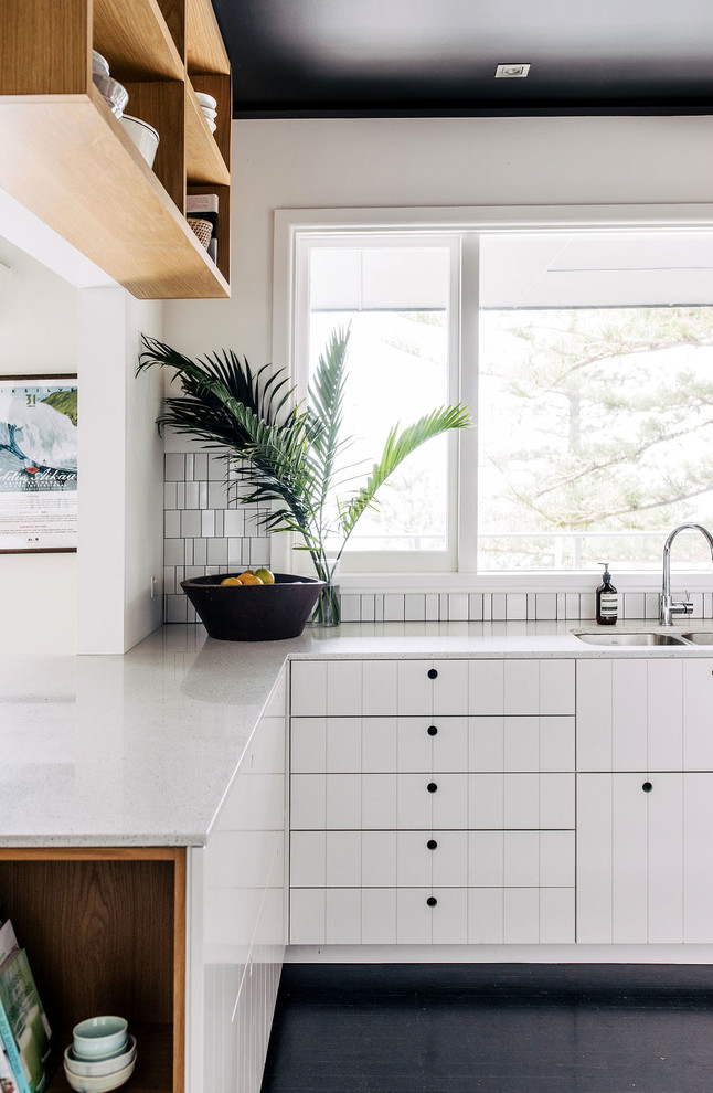 Moderne Küche in L-Form mit Doppelwaschbecken, weißen Schränken, Küchenrückwand in Weiß, Rückwand aus Mosaikfliesen, Halbinsel, schwarzem Boden, weißer Arbeitsplatte und gebeiztem Holzboden in Sydney