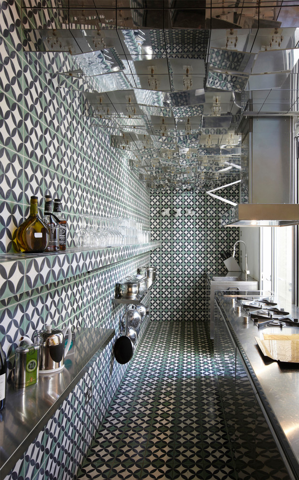 На фото: параллельная кухня в стиле фьюжн с столешницей из нержавеющей стали и красивой плиткой без острова