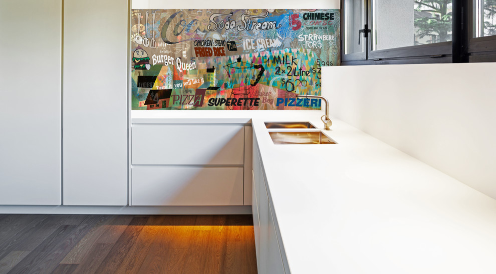 Esempio di una cucina contemporanea di medie dimensioni con ante bianche, top in superficie solida, paraspruzzi con lastra di vetro, pavimento in legno massello medio e pavimento marrone