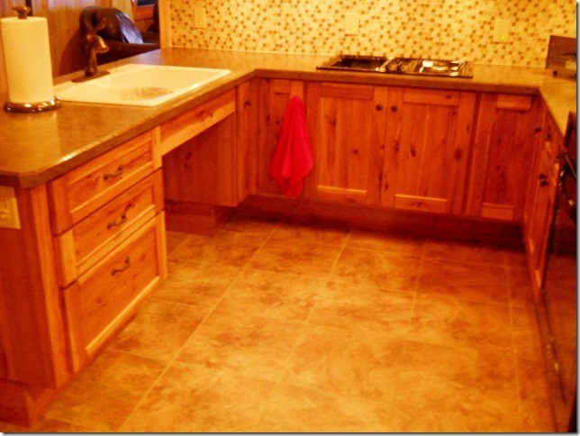 Küche in U-Form mit Vorratsschrank, Einbauwaschbecken, Schrankfronten im Shaker-Stil, hellbraunen Holzschränken, Keramikboden und Halbinsel in Sonstige