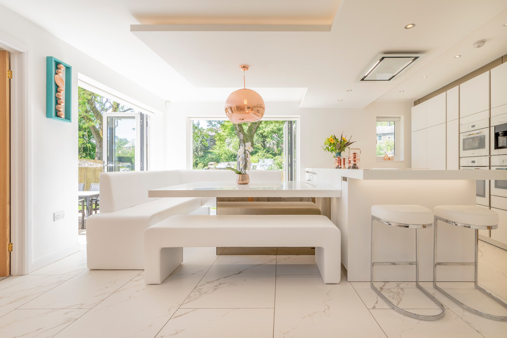 Exempel på ett stort modernt vit linjärt vitt kök, med släta luckor, vita skåp, bänkskiva i kvartsit, rostfria vitvaror, marmorgolv, en köksö och vitt golv