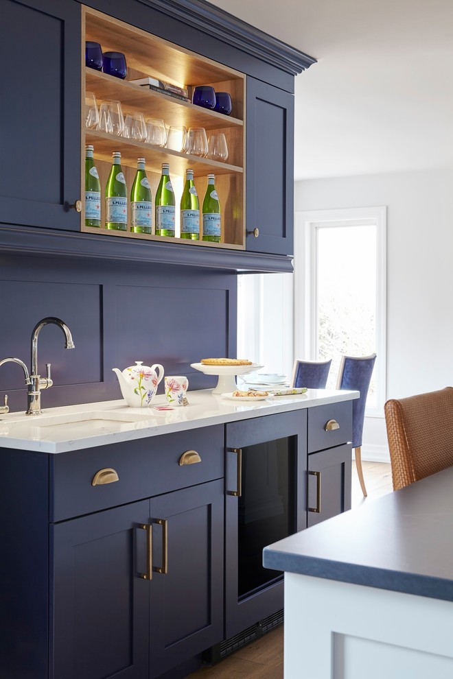 Exempel på ett mycket stort klassiskt blå blått kök, med en undermonterad diskho, skåp i shakerstil, blå skåp, bänkskiva i kvarts, integrerade vitvaror, ljust trägolv, en köksö och brunt golv