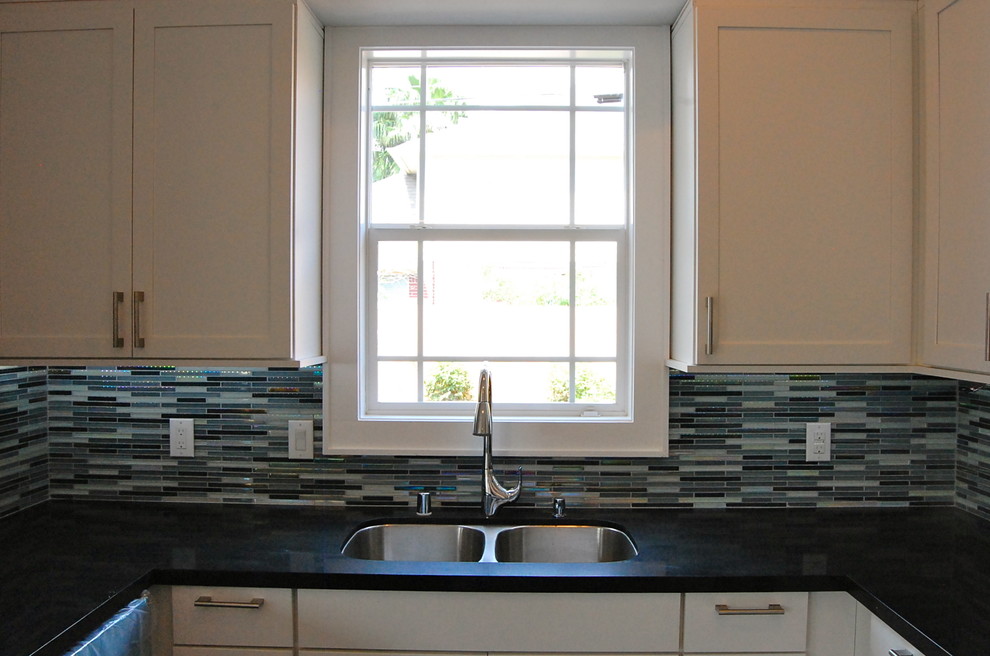 Foto di una cucina minimal di medie dimensioni con lavello sottopiano, ante in stile shaker, ante in legno bruno, top in quarzo composito, paraspruzzi blu, elettrodomestici in acciaio inossidabile e parquet scuro
