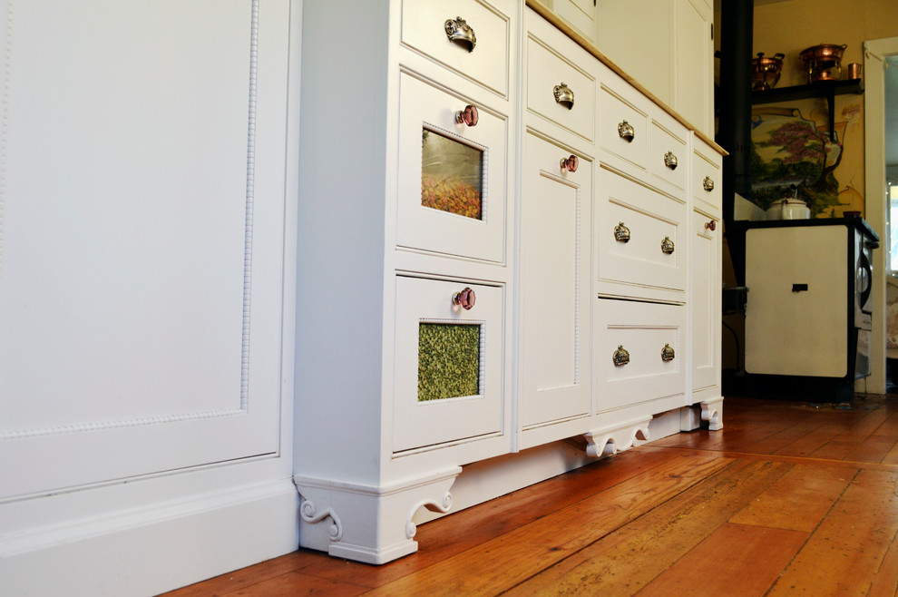 Exempel på ett mellanstort lantligt kök och matrum, med en integrerad diskho, luckor med profilerade fronter, vita skåp, marmorbänkskiva, integrerade vitvaror och mellanmörkt trägolv