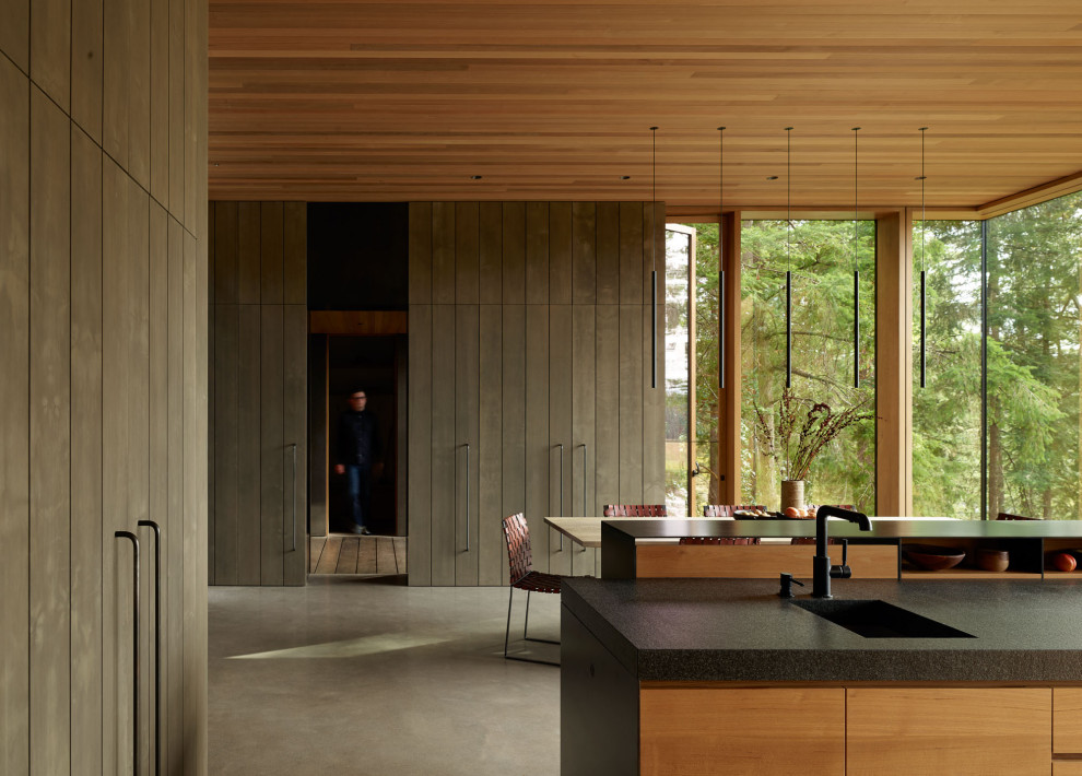 Idee per una grande cucina parallela moderna con ante lisce, top in granito, pavimento in cemento, 2 o più isole, top nero e soffitto in legno