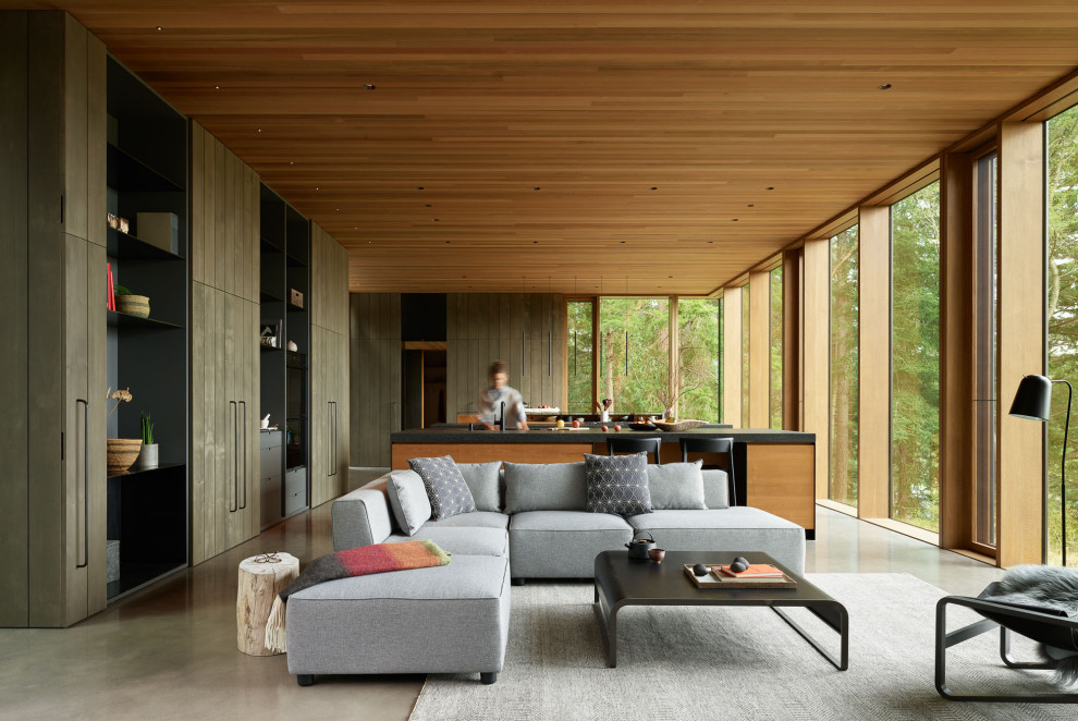 Inspiration for a large modern galley kitchen in Seattle with flat-panel cabinets, granite worktops, concrete flooring, multiple islands, black worktops and a wood ceiling.