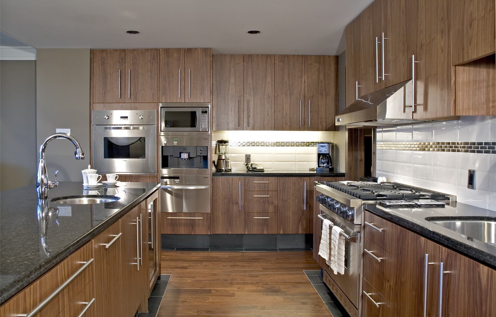 Moderne Küche mit Küchengeräten aus Edelstahl, Unterbauwaschbecken, flächenbündigen Schrankfronten, dunklen Holzschränken, Küchenrückwand in Weiß und Rückwand aus Metrofliesen in Vancouver