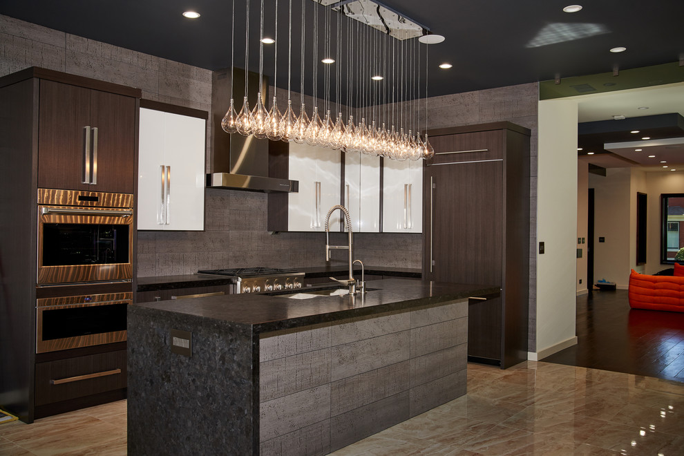 Contemporary l-shaped kitchen in Chicago with a submerged sink, flat-panel cabinets, dark wood cabinets, grey splashback, integrated appliances, an island, brown floors and black worktops.