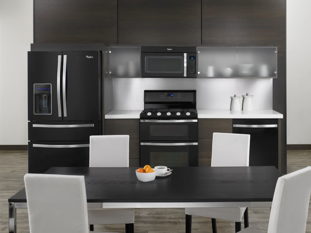 Ejemplo de cocina comedor lineal moderna pequeña con armarios con paneles lisos, puertas de armario de madera en tonos medios y electrodomésticos negros