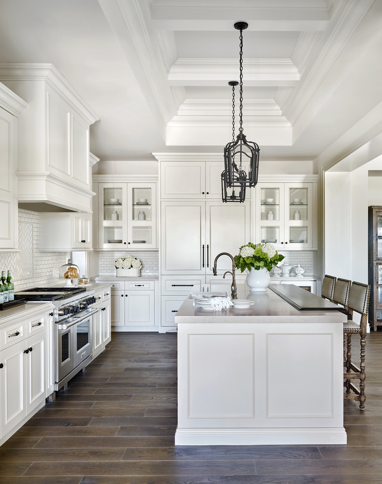 Elegant l-shaped kitchen photo in Phoenix with an undermount sink, shaker cabinets, white cabinets, white backsplash, subway tile backsplash, stainless steel appliances and an island