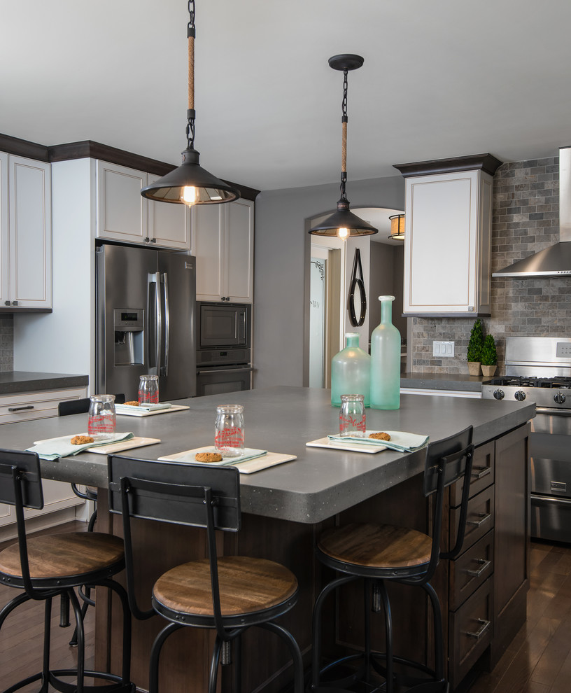 Example of a transitional dark wood floor kitchen design in Detroit with recessed-panel cabinets, white cabinets, multicolored backsplash, subway tile backsplash, stainless steel appliances and an island