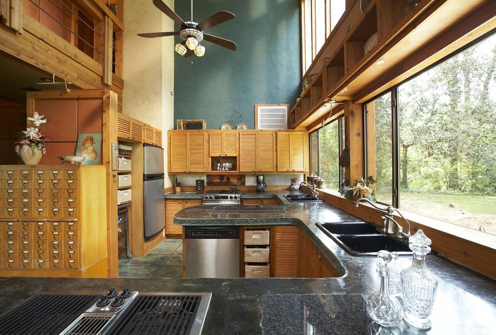 На фото: кухня в стиле рустика с двойной мойкой, фасадами цвета дерева среднего тона, техникой из нержавеющей стали, полуостровом и окном