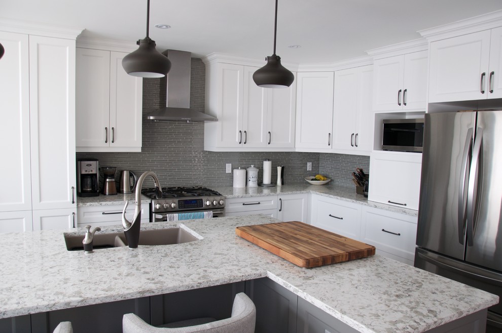 Bild på ett mellanstort funkis kök, med en undermonterad diskho, skåp i shakerstil, vita skåp, bänkskiva i kvartsit, grått stänkskydd, stänkskydd i mosaik, rostfria vitvaror, klinkergolv i porslin, en köksö och grått golv