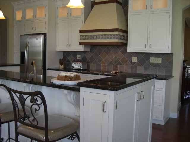 Esempio di una cucina chic con lavello sottopiano, ante in stile shaker, ante gialle, top in granito, paraspruzzi arancione, paraspruzzi in gres porcellanato e elettrodomestici in acciaio inossidabile