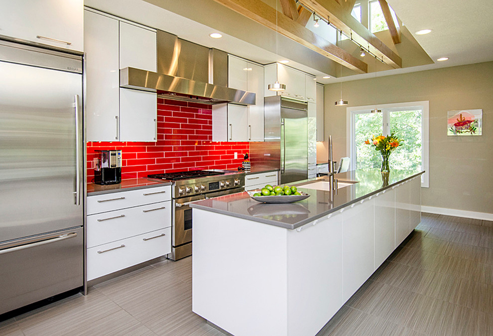 Photo of a medium sized contemporary l-shaped kitchen/diner in Other with a single-bowl sink, flat-panel cabinets, white cabinets, composite countertops, red splashback, metro tiled splashback, stainless steel appliances, light hardwood flooring and an island.