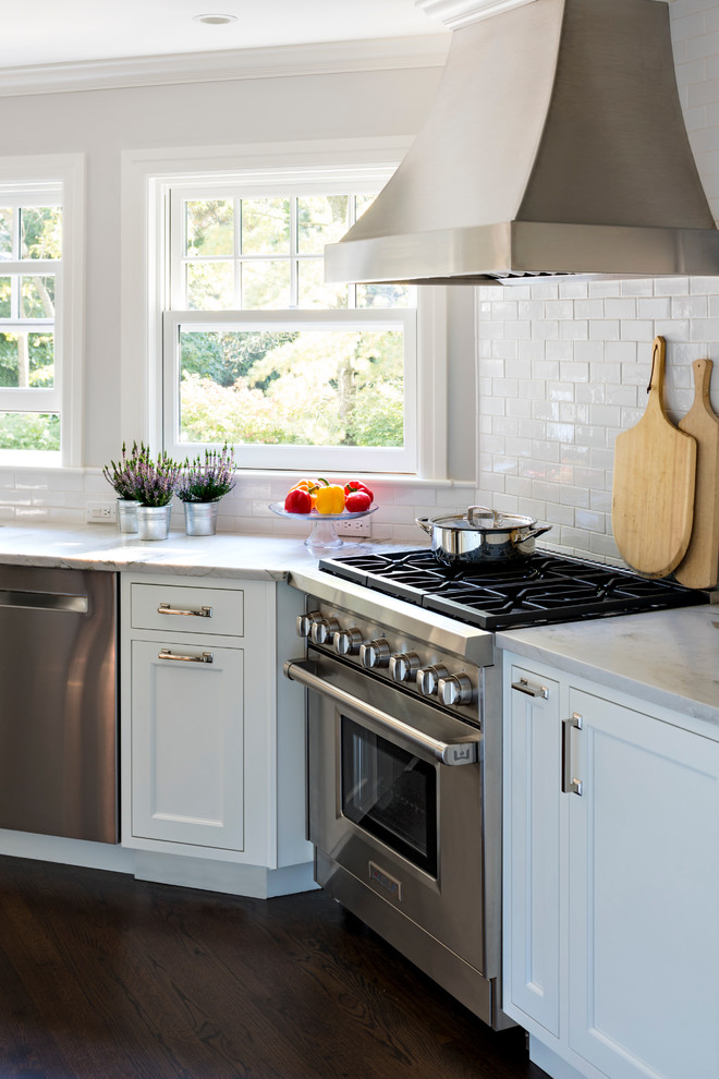 Eat-in kitchen - mid-sized transitional l-shaped dark wood floor eat-in kitchen idea in New York with an undermount sink, shaker cabinets, white cabinets, quartzite countertops, white backsplash, ceramic backsplash, stainless steel appliances and an island