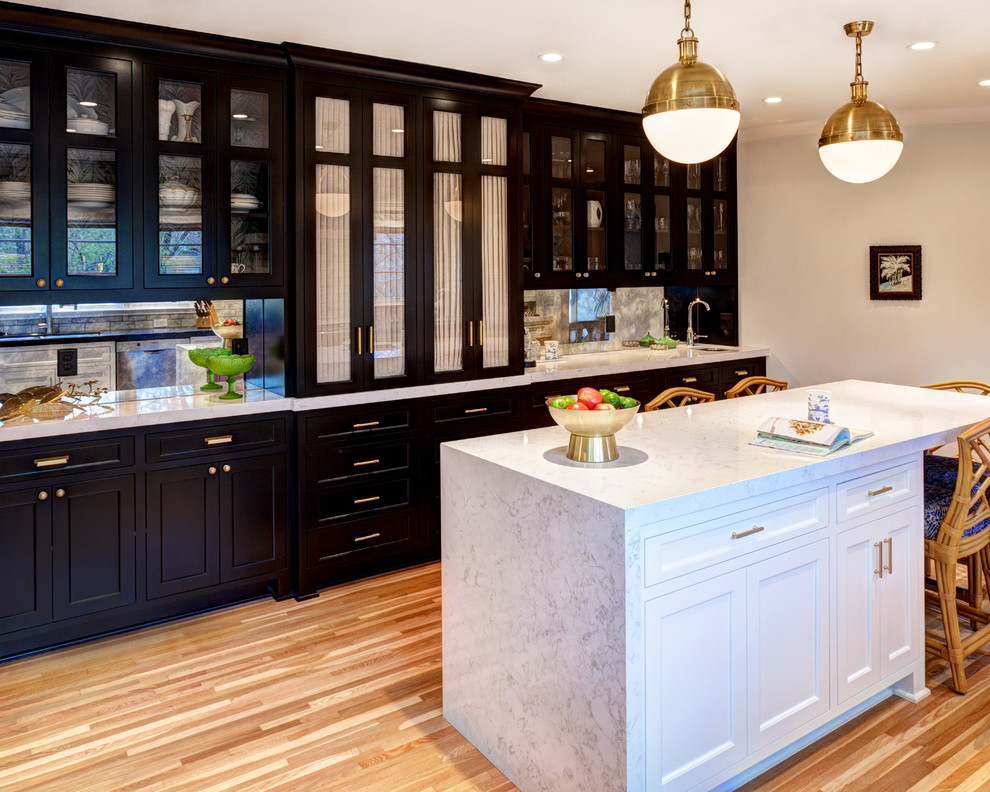 Example of a mid-sized classic medium tone wood floor enclosed kitchen design in Minneapolis with a double-bowl sink, flat-panel cabinets, white cabinets, quartz countertops, gray backsplash, mirror backsplash, stainless steel appliances and an island