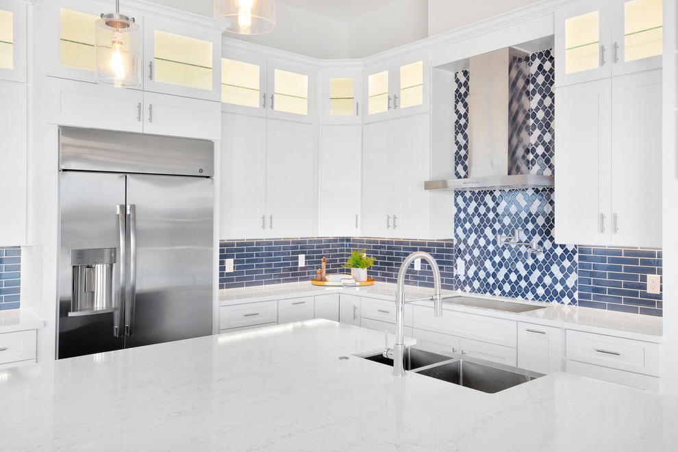 Eat-in kitchen - large modern l-shaped medium tone wood floor and brown floor eat-in kitchen idea in Phoenix with an undermount sink, shaker cabinets, white cabinets, quartz countertops, blue backsplash, ceramic backsplash, stainless steel appliances, an island and white countertops