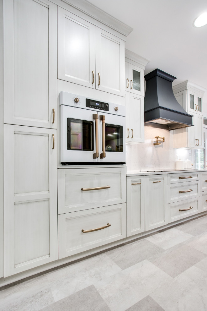 Immagine di un grande cucina con isola centrale minimal con lavello sottopiano, top in quarzo composito e elettrodomestici bianchi