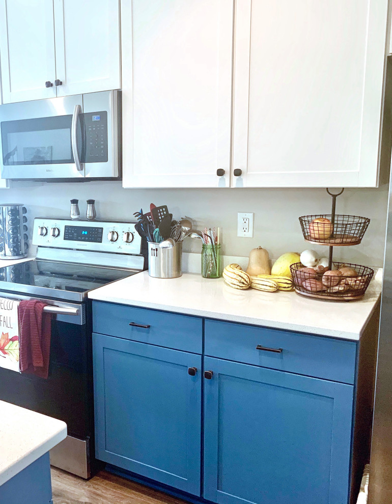 Offene, Einzeilige, Kleine Moderne Küche mit Einbauwaschbecken, Schrankfronten im Shaker-Stil, blauen Schränken, Quarzit-Arbeitsplatte, Küchengeräten aus Edelstahl, braunem Holzboden, Kücheninsel, braunem Boden, weißer Arbeitsplatte und eingelassener Decke in Charleston