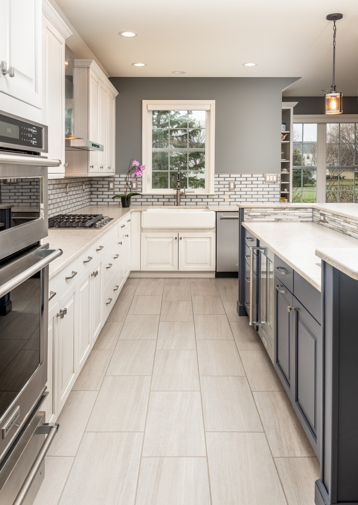 Design ideas for a large traditional kitchen in Philadelphia with a belfast sink, raised-panel cabinets, engineered stone countertops, stainless steel appliances and an island.