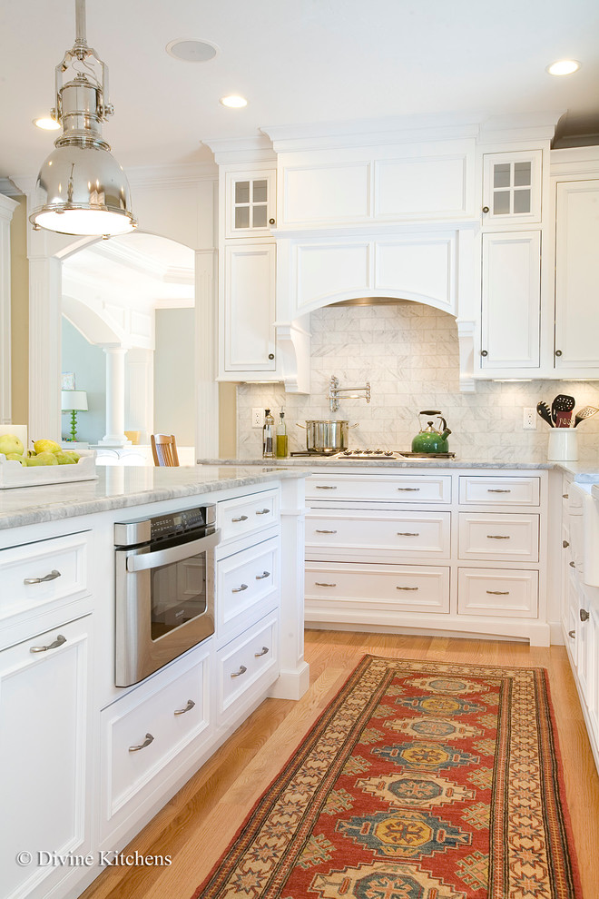 Zweizeilige, Große Klassische Wohnküche mit Landhausspüle, Kassettenfronten, gelben Schränken, Granit-Arbeitsplatte, Küchenrückwand in Weiß, Küchengeräten aus Edelstahl, hellem Holzboden und Kücheninsel in Boston