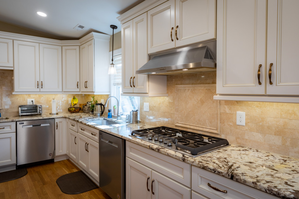 Immagine di una grande cucina chic con lavello sottopiano, ante in stile shaker, top in granito, elettrodomestici in acciaio inossidabile e pavimento in legno massello medio
