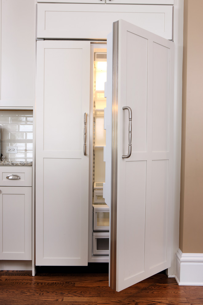 Inspiration for a large timeless l-shaped medium tone wood floor eat-in kitchen remodel in Chicago with shaker cabinets, white cabinets, granite countertops, white backsplash, subway tile backsplash and paneled appliances