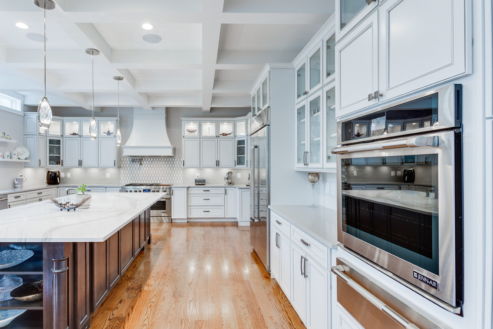 Design ideas for a large classic u-shaped kitchen in DC Metro with a submerged sink, recessed-panel cabinets, engineered stone countertops, stainless steel appliances, medium hardwood flooring and an island.