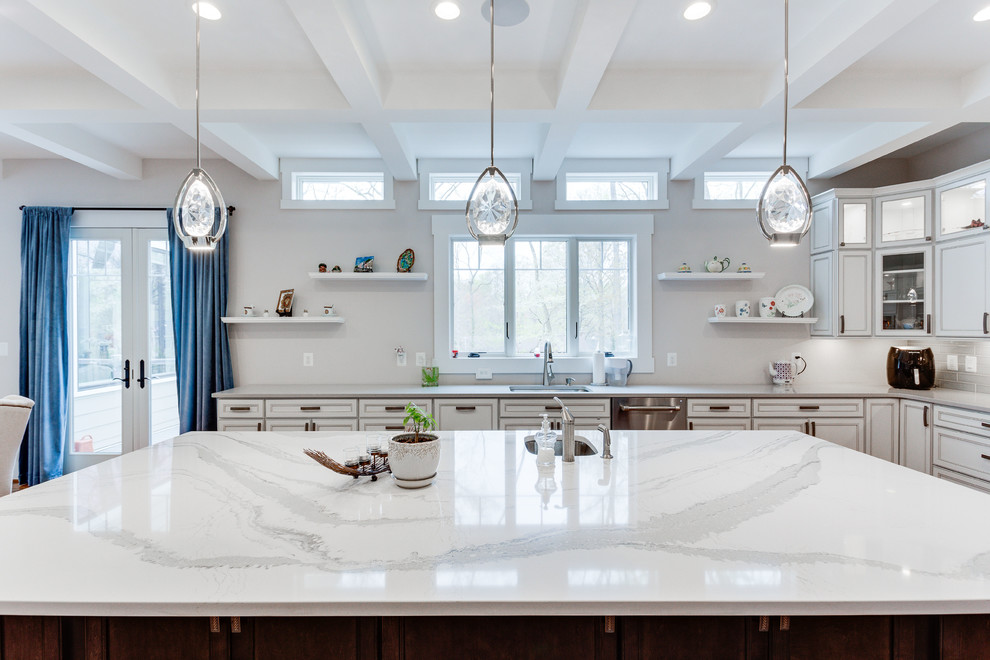 Example of a large classic u-shaped medium tone wood floor kitchen design in DC Metro with an undermount sink, recessed-panel cabinets, quartz countertops, stainless steel appliances and an island