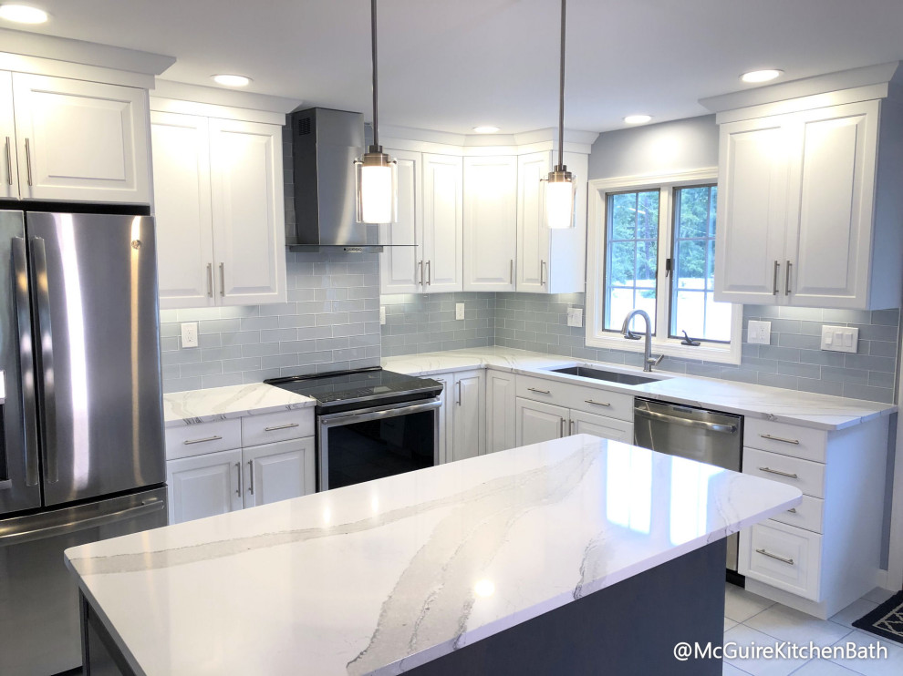 Klassische Küche in L-Form mit Unterbauwaschbecken, weißen Schränken, Rückwand aus Glasfliesen, Küchengeräten aus Edelstahl und Kücheninsel in Boston
