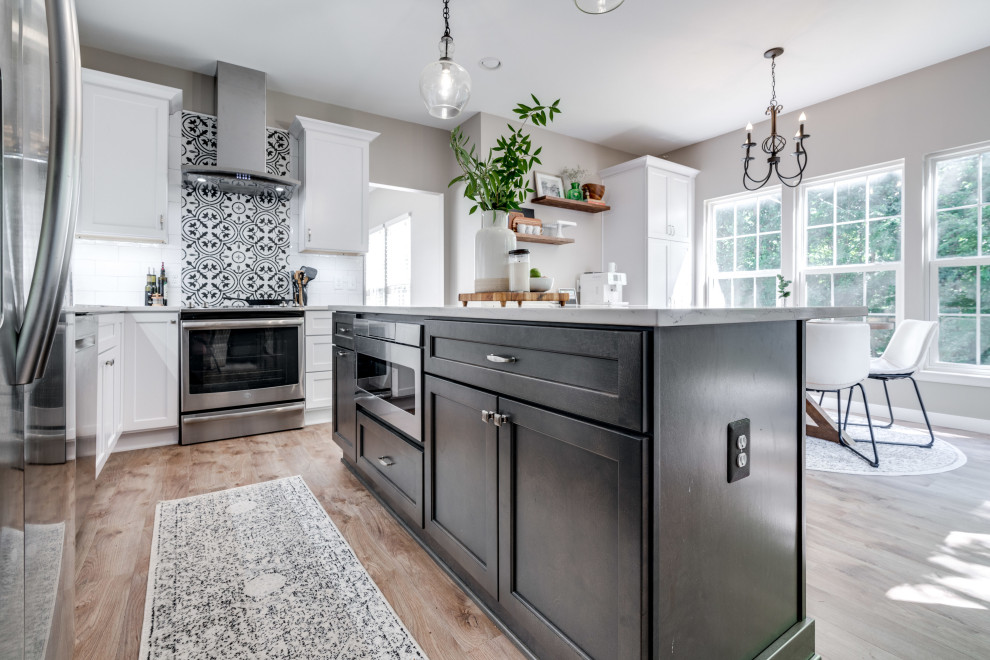 Mid-sized transitional l-shaped medium tone wood floor open concept kitchen photo in DC Metro with an undermount sink, shaker cabinets, quartz countertops, subway tile backsplash, stainless steel appliances and an island