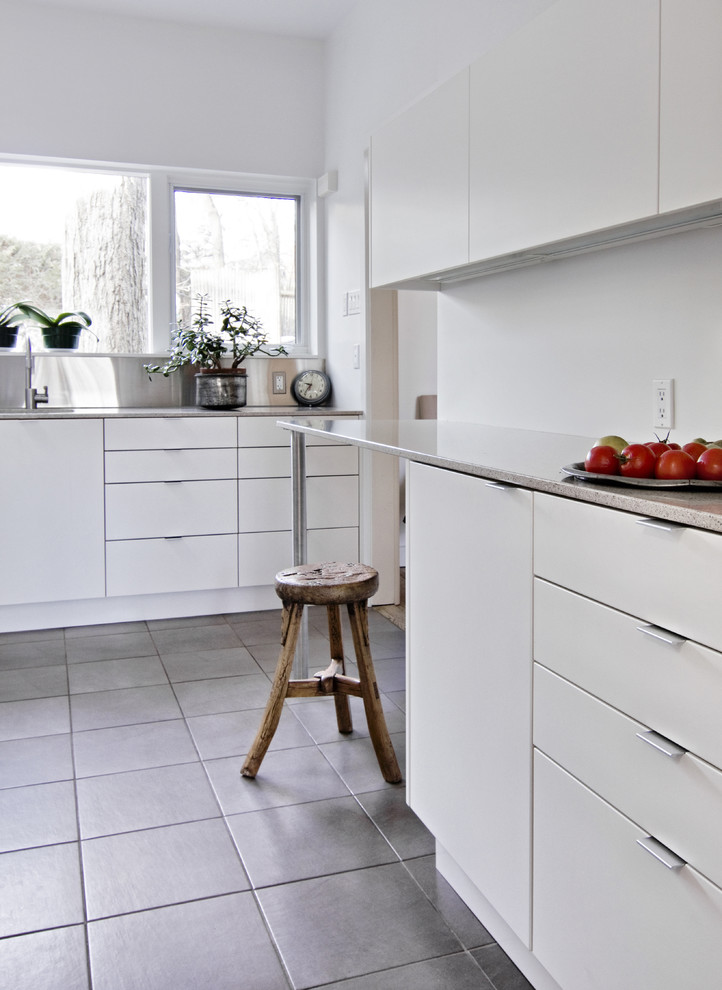 Moderne Küche mit flächenbündigen Schrankfronten, weißen Schränken, Quarzwerkstein-Arbeitsplatte und grauem Boden in Ottawa
