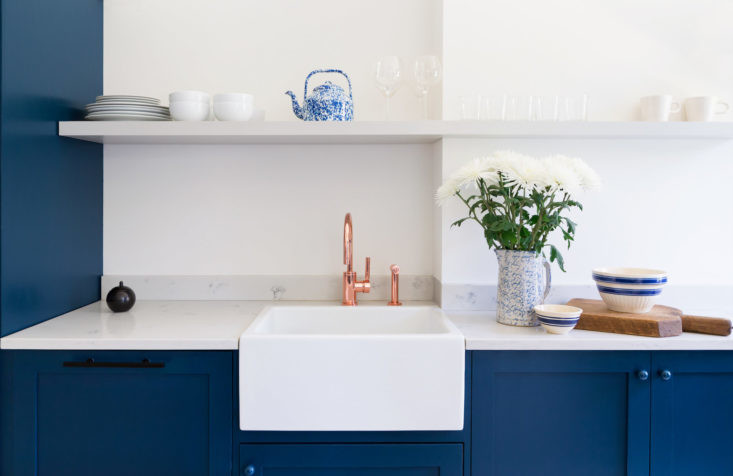 Design ideas for a small coastal galley kitchen/diner in Other with a belfast sink, shaker cabinets, blue cabinets, marble worktops, stainless steel appliances, light hardwood flooring and no island.
