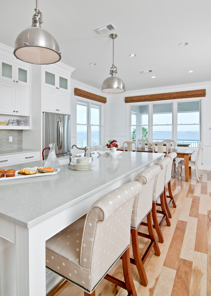 Inspiration for a timeless eat-in kitchen remodel in Other with quartz countertops, white cabinets, stainless steel appliances and gray backsplash