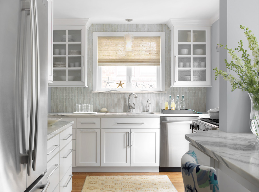 Inspiration for a coastal medium tone wood floor kitchen remodel in St Louis with an undermount sink, shaker cabinets, white cabinets, gray backsplash, stainless steel appliances, marble countertops and matchstick tile backsplash