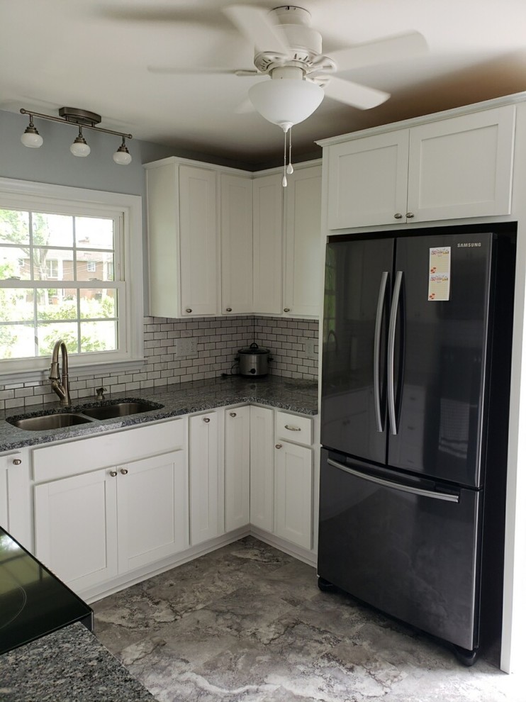 Foto på ett avskilt, litet rustikt flerfärgad u-kök, med en undermonterad diskho, skåp i shakerstil, vita skåp, granitbänkskiva, vitt stänkskydd, stänkskydd i tunnelbanekakel, svarta vitvaror, vinylgolv och grått golv