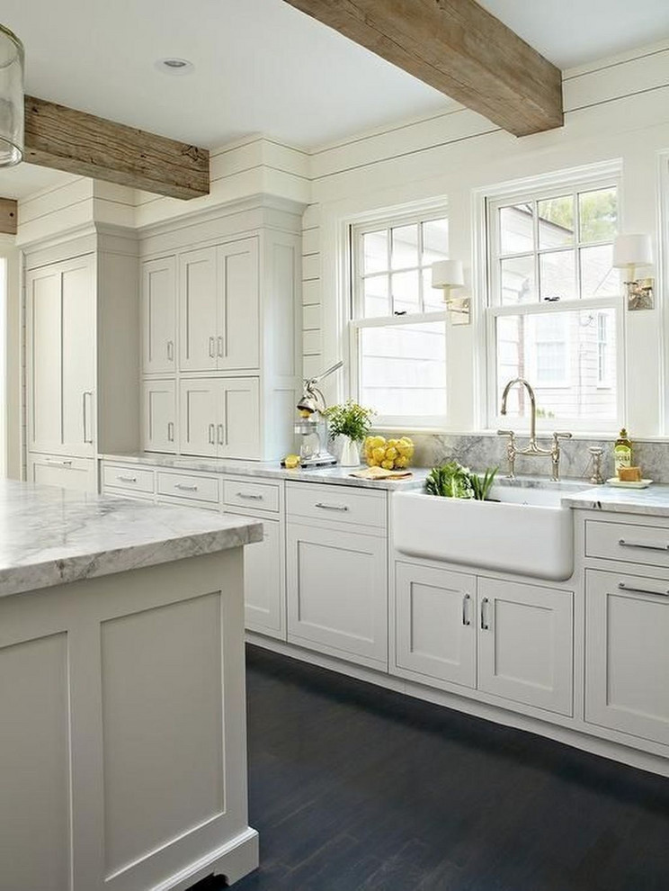 Example of a large classic l-shaped dark wood floor and brown floor eat-in kitchen design in Columbus with a farmhouse sink, recessed-panel cabinets, white cabinets, marble countertops, gray backsplash, marble backsplash, paneled appliances, an island and gray countertops