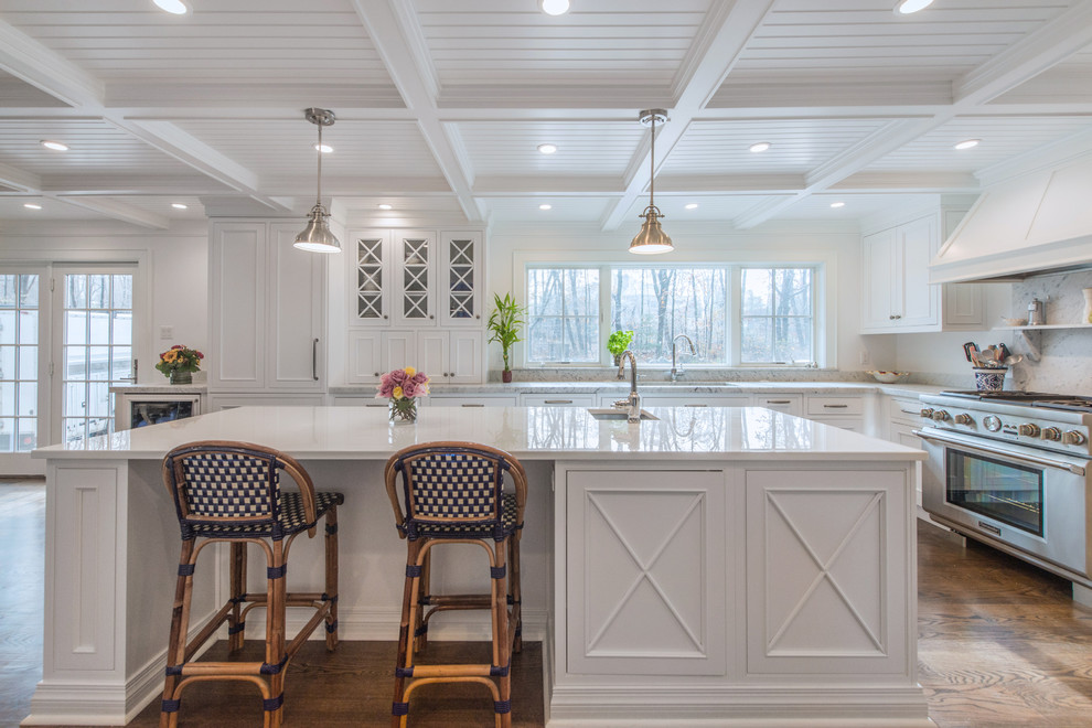 Design ideas for a large traditional l-shaped kitchen/diner with a submerged sink, beaded cabinets, white cabinets, glass worktops, stainless steel appliances, medium hardwood flooring and an island.