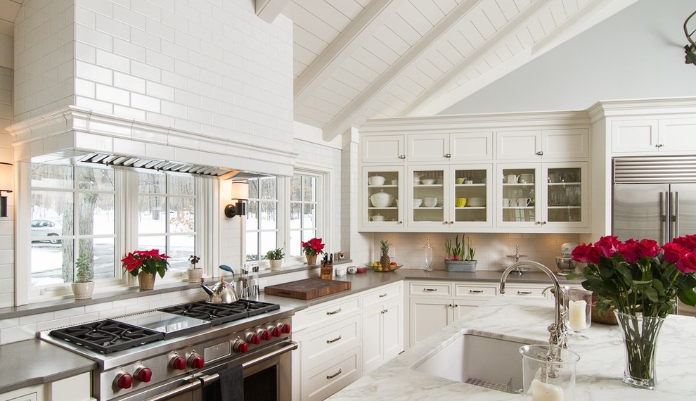 Example of a large trendy l-shaped eat-in kitchen design in Minneapolis with an undermount sink, recessed-panel cabinets, white cabinets, marble countertops, white backsplash, subway tile backsplash, stainless steel appliances and an island