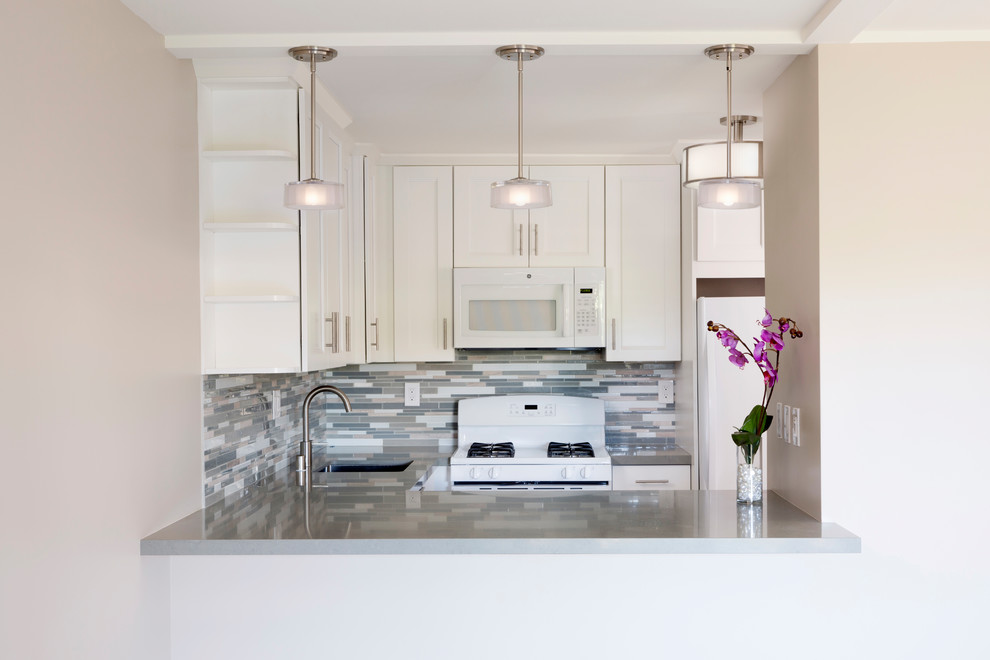 Inspiration for a small transitional u-shaped porcelain tile and gray floor kitchen remodel in Hawaii with a single-bowl sink, shaker cabinets, white cabinets, gray backsplash, mosaic tile backsplash, white appliances and no island