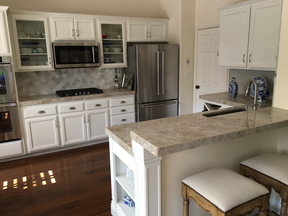 Photo of a medium sized farmhouse u-shaped open plan kitchen in Los Angeles with a submerged sink, open cabinets, white cabinets, quartz worktops, multi-coloured splashback, mosaic tiled splashback, stainless steel appliances, dark hardwood flooring and a breakfast bar.