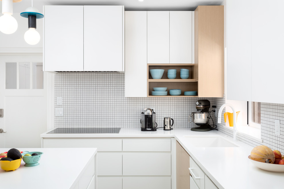 Idéer för ett avskilt, mellanstort modernt vit l-kök, med en undermonterad diskho, släta luckor, vita skåp, bänkskiva i kvarts, vitt stänkskydd, svarta vitvaror, cementgolv, en köksö och grått golv