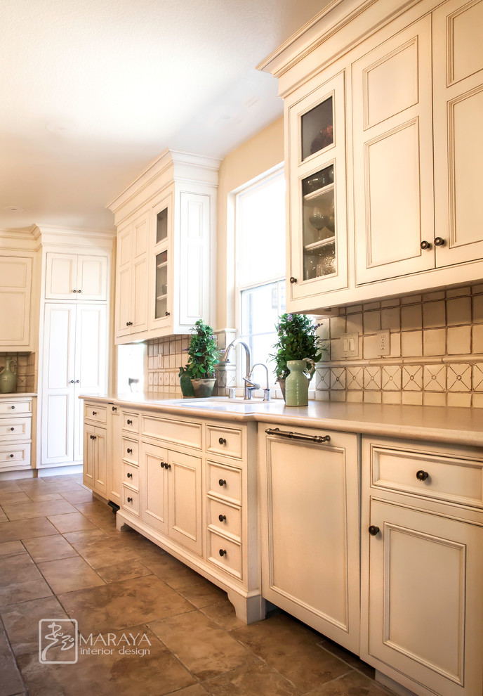 Foto på ett stort lantligt kök, med en rustik diskho, luckor med infälld panel, vita skåp, marmorbänkskiva, vitt stänkskydd, stänkskydd i keramik, integrerade vitvaror, kalkstensgolv och en köksö