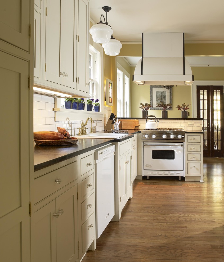 アトランタにあるトラディショナルスタイルのおしゃれなキッチン (ドロップインシンク、シェーカースタイル扉のキャビネット、ベージュのキャビネット、白いキッチンパネル、サブウェイタイルのキッチンパネル、白い調理設備) の写真